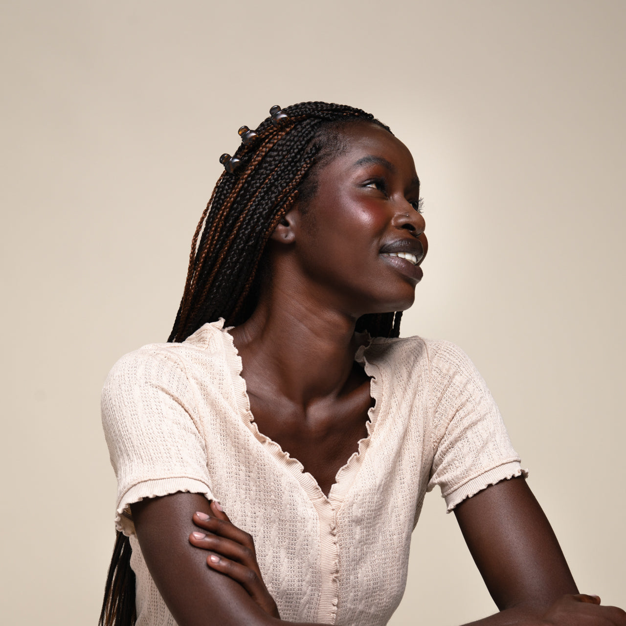 Model wearing tort Micro Cloud Clips throughout long braided hair against a neutral background