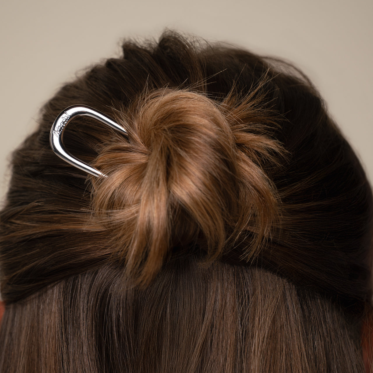 Close-up of a half-up hair bun with the kitsch silver mini metal french clip.
