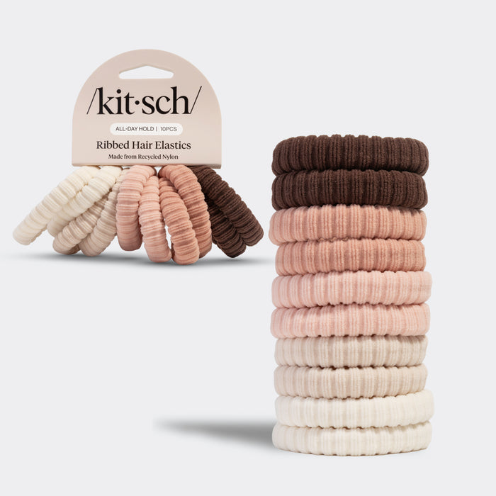 Stack of kitsch blush ribbed hair elastics with the packaged version of the hair elastics  on a light gray background