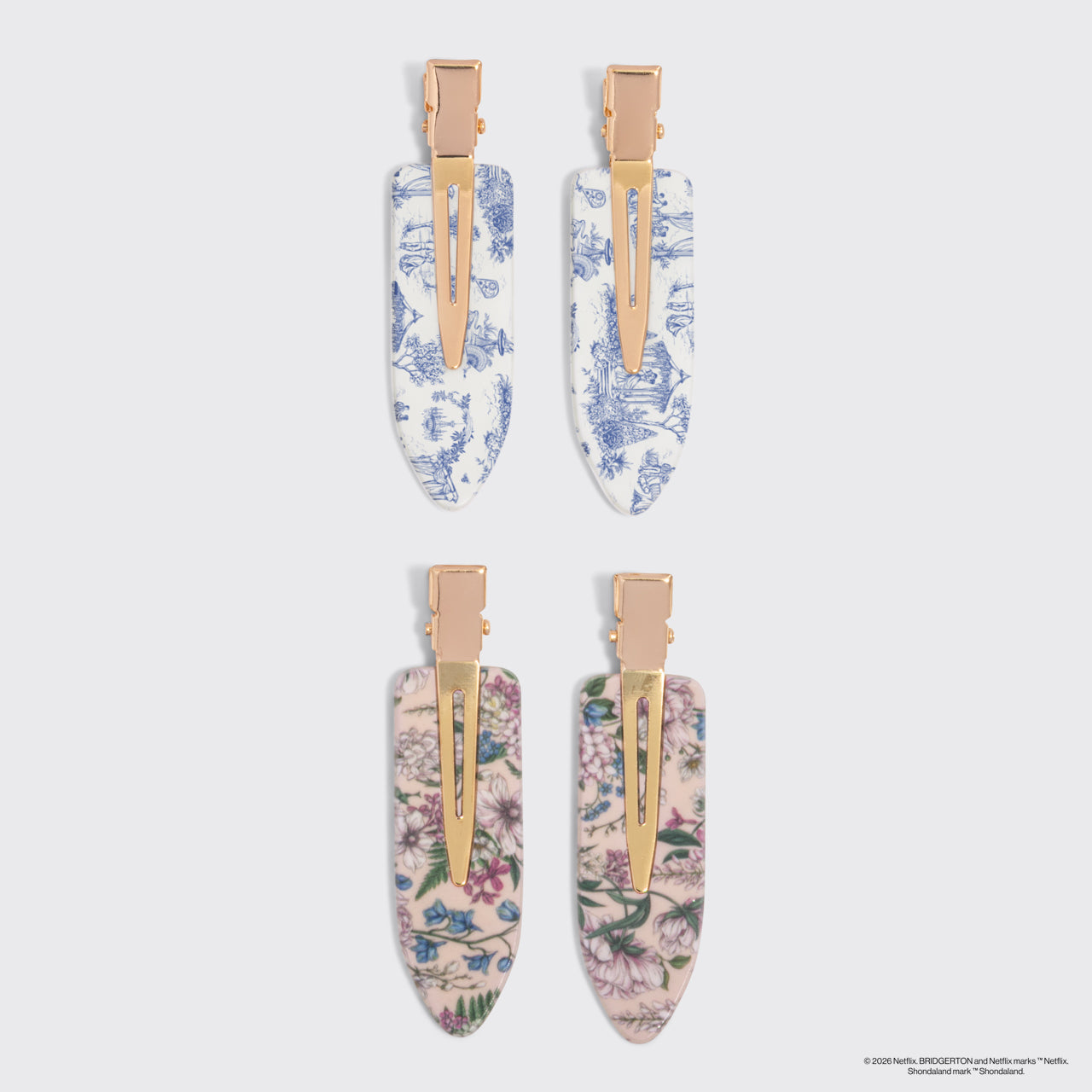 Bridgerton x Kitsch Creaseless Clips in Toile in Bloom, four hair claw clips arranged in a 2x2 grid on a gray background. The top pair has a blue and white toile floral pattern, and the bottom pair has a pink and beige floral pattern.