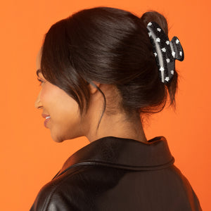 Model wearing the Recycled Plastic Glitter Claw Clip in Ghosts securing a sleek bun.