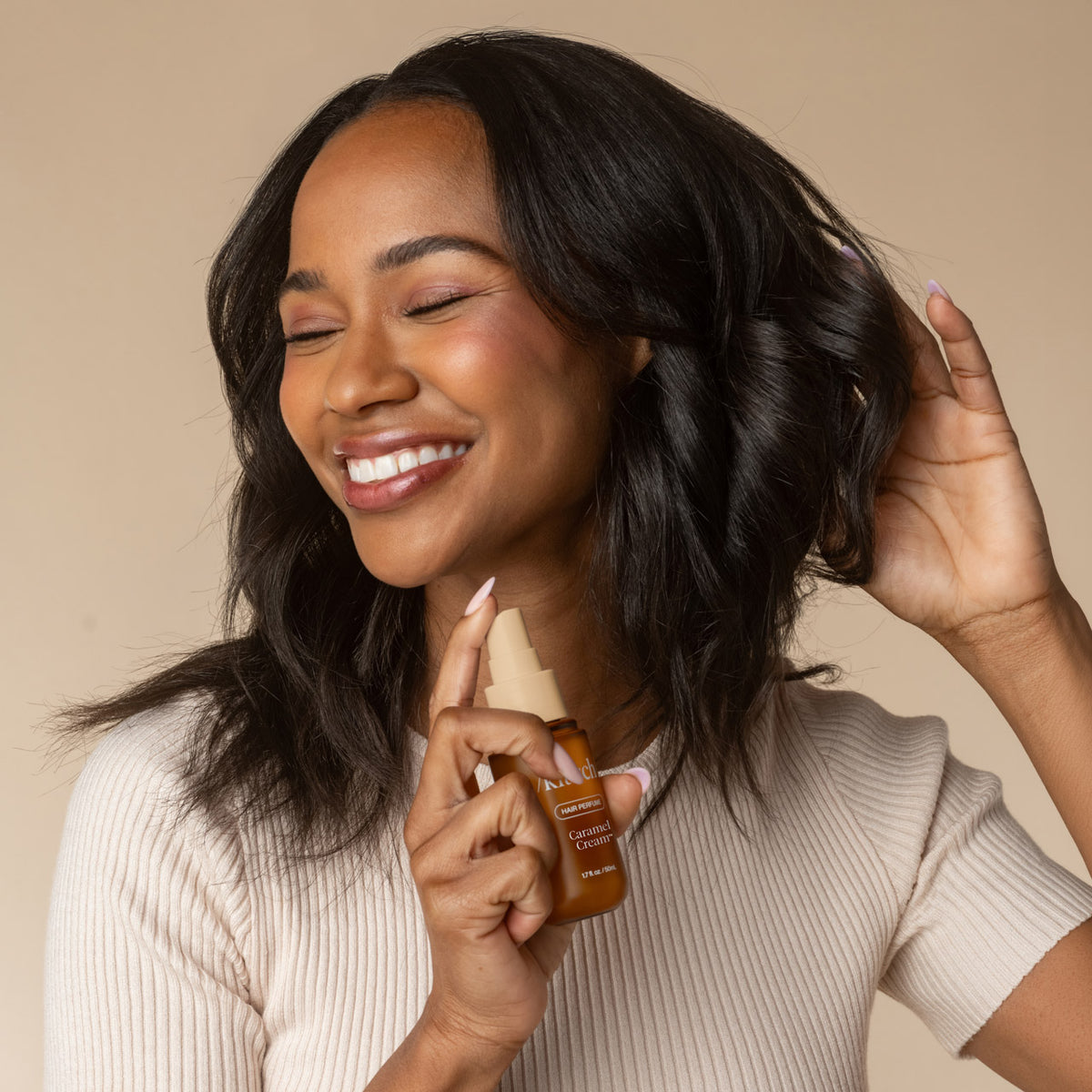 KITSCH Cozy Corner Duo: Soft Santal & Caramel Cream — model spritzing, Caramel Cream — smells like creamy caramel & whipped vanilla with a warm, woody finish that's sweet yet sophisticated — spritz onto dry hair for an instant refresh