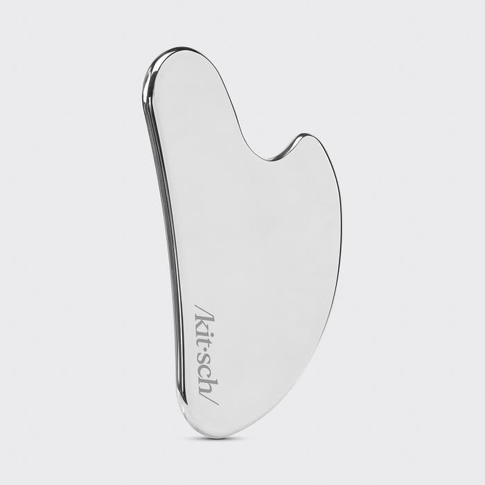 Model using Stainless Steel Gua Sha along jawline showing 15-degree angle technique