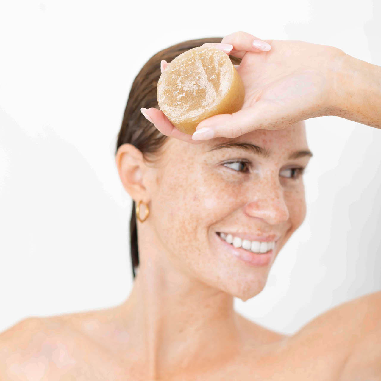 Model holding the Kitsch Sugar Solid Body Scrub Bar after use, showcasing the bottle-free exfoliating body scrub bar.