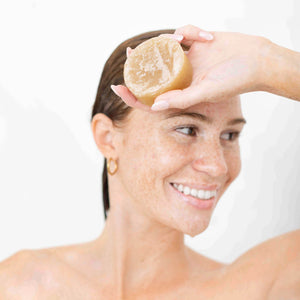 Model holding the Kitsch Sugar Solid Body Scrub Bar after use, showcasing the bottle-free exfoliating body scrub bar.