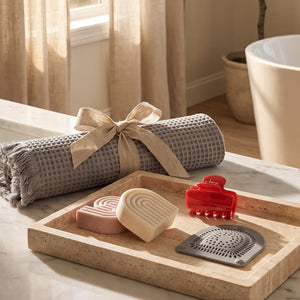 Quick-Dry Bath Mat, Hair Catcher, Cherry Cloud Claw Clip, and Shampoo & Conditioner Bars styled together in a bright bathroom to showcase the Summer Welcome Kit free gifts.